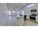 Open-concept living room into kitchen features a sleek island, modern appliances, and lots of natural light at 3721 Brentcove Dr, North Las Vegas, NV 89032