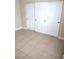 Bedroom with sliding closet doors and tile flooring at 4260 Vornsand Dr, Las Vegas, NV 89115