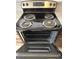 Open oven door of electric range stove with black cooktop and silver dials at 4260 Vornsand Dr, Las Vegas, NV 89115