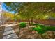 A Backyard with landscaped pathway, mature trees, and inviting rock features at 43 Grey Feather Dr, Las Vegas, NV 89135