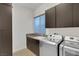 Efficient laundry room featuring modern appliances and ample storage cabinets at 43 Grey Feather Dr, Las Vegas, NV 89135