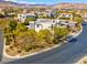 Street view of a contemporary home surrounded by lush landscaping and mature trees, mountains in the background at 43 Grey Feather Dr, Las Vegas, NV 89135
