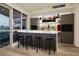 Contemporary home bar with stools, backlit countertop, glass shelving, and cabinets at 4575 Dean Martin Dr # 2400, Las Vegas, NV 89103