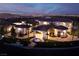 Aerial view of the estate at night showcases a circular driveway, water feature, and city skyline in background at 48 Augusta Canyon Way, Las Vegas, NV 89141