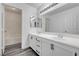 A bright bathroom features double sinks with white cabinets, neutral colored walls and a shower over tub at 58 Desert Castle Ct, Henderson, NV 89012