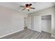 Bedroom with modern ceiling fan, wood-look floors, closet and adjacent bathroom at 58 Desert Castle Ct, Henderson, NV 89012