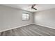 Empty bedroom with gray wood floors, window with a view, and ceiling fan at 58 Desert Castle Ct, Henderson, NV 89012