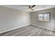 Bedroom with gray wood floors, neutral walls, a ceiling fan, and large window at 58 Desert Castle Ct, Henderson, NV 89012