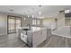 Modern kitchen featuring an oversized island, stainless sink, and open design leading to outdoor space and the staircase at 58 Desert Castle Ct, Henderson, NV 89012