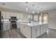 Modern kitchen with stainless steel appliances, gray cabinetry, large center island, and stylish pendant lighting at 58 Desert Castle Ct, Henderson, NV 89012