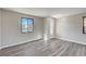 Bright living room featuring modern gray wood floors, neutral walls, and an exterior door at 58 Desert Castle Ct, Henderson, NV 89012