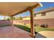 Covered patio featuring tile flooring and artificial turf with brick wall surroundings at 58 Desert Castle Ct, Henderson, NV 89012