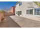 This backyard includes a brick-paved patio, desert landscaping, and a stucco house with windows at 7203 Pepperbox Ave, Las Vegas, NV 89179