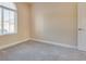 Neutral bedroom featuring carpeted floor, base trim, a window, and a door at 7203 Pepperbox Ave, Las Vegas, NV 89179