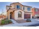Two-story home with desert landscaping featuring a two-car garage, arched entryway, and gray shutters at 7203 Pepperbox Ave, Las Vegas, NV 89179