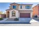 Two-story home with a two-car garage, arched entryway, and desert landscaping at 7203 Pepperbox Ave, Las Vegas, NV 89179