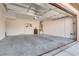 Spacious garage with ample room for parking and storage with neutral color palette and lighting fixture at 7203 Pepperbox Ave, Las Vegas, NV 89179