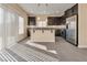 Spacious kitchen with stainless steel appliances, an island and dark cabinets and gray countertops at 7203 Pepperbox Ave, Las Vegas, NV 89179