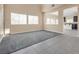 An open living room offers natural light, carpeted floors and access to the adjacent kitchen at 7203 Pepperbox Ave, Las Vegas, NV 89179