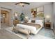 Staged primary bedroom with ceiling fan, bench, bedside tables and art at 7203 Pepperbox Ave, Las Vegas, NV 89179