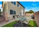 Outdoor space with dining area, grill, artificial turf, and brick wall providing a cozy and private retreat at 7856 Pyramid Peak St, Las Vegas, NV 89166