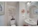 Stylish half-bathroom with pedestal sink, decorative mirror, and modern fixtures for guests at 7856 Pyramid Peak St, Las Vegas, NV 89166