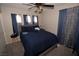 Bedroom with gray carpet, blue bedding, dark curtains and ceiling fan at 916 Echo Beach Ave, North Las Vegas, NV 89086