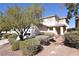 Beige two-story single Gathering home with desert landscaping including several small bushes and a decorative tree at 916 Echo Beach Ave, North Las Vegas, NV 89086