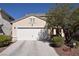 Beige single Gathering home with a two car garage and a concrete driveway and desert landscaping at 916 Echo Beach Ave, North Las Vegas, NV 89086