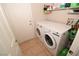Laundry room with washer, dryer, shelving, and tiled floors at 916 Echo Beach Ave, North Las Vegas, NV 89086