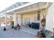 A cozy covered patio with a tile floor is nicely decorated with potted plants and features a grill and seating at 916 Echo Beach Ave, North Las Vegas, NV 89086