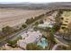 Estate aerial view showcasing lush landscaping, a pool, and stunning views of the golf course and the surrounding mountains at 10 Innisbrook Ave, Las Vegas, NV 89113