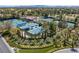 Aerial view of multiple tennis courts with a clubhouse and pool, surrounded by lush landscaping and mature trees at 10 Innisbrook Ave, Las Vegas, NV 89113