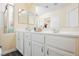 Bright bathroom with white cabinets and countertop, double sinks, and vanity lighting at 10448 Niagara Falls Ln, Las Vegas, NV 89144