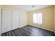 Cozy bedroom with modern gray wood floors, a spacious closet, and a bright window with sheer curtains at 10448 Niagara Falls Ln, Las Vegas, NV 89144