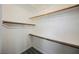 Walk-in closet with wood rods, shelving, and grey wood-look flooring at 10448 Niagara Falls Ln, Las Vegas, NV 89144