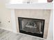 Close-up of the living room fireplace with decorative mantle, glass doors, and neutral tile surround at 10448 Niagara Falls Ln, Las Vegas, NV 89144
