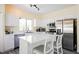 Bright kitchen with stainless steel appliances, white cabinetry, and large center island with barstool seating at 10448 Niagara Falls Ln, Las Vegas, NV 89144