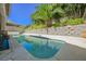 Refreshing backyard pool featuring a well-maintained yard and a retaining wall at 10448 Niagara Falls Ln, Las Vegas, NV 89144