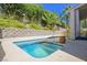 Relaxing backyard pool and spa featuring a retaining wall and lush green landscaping at 10448 Niagara Falls Ln, Las Vegas, NV 89144