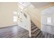 Bright open floorplan features staircase with decorative display shelving and wood-look floors at 10448 Niagara Falls Ln, Las Vegas, NV 89144