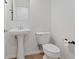 Quaint powder room featuring a pedestal sink, toilet, and tile floors at 11428 Belmont Lake Dr # 104, Las Vegas, NV 89135
