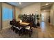 Dining room with modern decor, a large window, a rustic table and chairs, and a dark bookcase at 11860 Star Grass Ave, Las Vegas, NV 89138