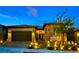 Inviting exterior view of a home showcasing the front door and manicured landscaping with landscape lighting at 11860 Star Grass Ave, Las Vegas, NV 89138