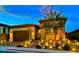 Beautiful single-story home with stone accents and a landscaped front yard illuminated at night at 11860 Star Grass Ave, Las Vegas, NV 89138