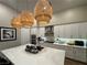 A modern kitchen with a large island, quartz countertops and decorative pendant lights at 11860 Star Grass Ave, Las Vegas, NV 89138