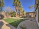 Lush backyard featuring a well-maintained lawn, mature trees, and a covered patio for outdoor enjoyment at 1402 Bareback Ct, Henderson, NV 89014