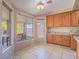 Bright eat-in kitchen nook featuring tile floors, wood cabinets, and views of the backyard at 1402 Bareback Ct, Henderson, NV 89014