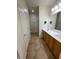 Well-lit bathroom featuring a double sink vanity, large mirror and tiled floor at 2341 Celestial Moon St, Henderson, NV 89044