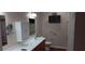 Bathroom featuring a long vanity, cabinet, mirror, and a mounted television for convenience at 2601 Centaurus St, Henderson, NV 89044